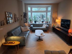 a living room with a couch and a table at Zee-en-Zo Noordwijk in Noordwijk