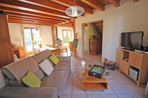 a living room with a couch and a tv at Les tilleuls in Glanges