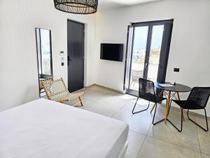 a bedroom with a bed and a table and chairs at myLithos Suites in Monolithos