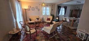 a living room with chairs and a table and a dining room at LA MAISON DU MUGUET - Accueil Chevaux - Horse Friendly in Liart +21 photos
