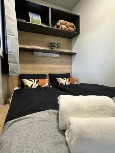 a bedroom with two beds and a shelf with pillows at Forest House Razanac in Ražanac