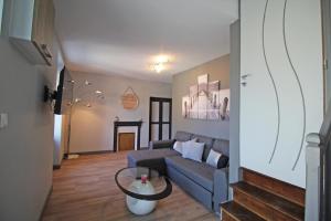 a living room with a couch and a table at Le paradis de caux in Magnac-Bourg
