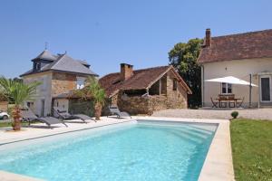 a swimming pool in front of a house at Le paradis de caux in Magnac-Bourg