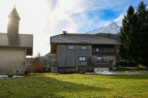 a large wooden house with a mountain in the background at Le chalet d'en ô in Les Clefs
