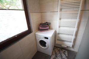 a washing machine in a bathroom with a window at Ferienwohnung Rennsteigblick in Riechheim