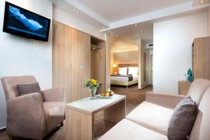 a living room with a couch and a tv on a wall at Best Western Hotel zur Post in Bremen