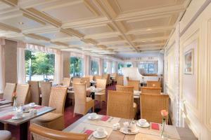 a dining room with tables and chairs and windows at Best Western Hotel zur Post in Bremen