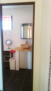 La salle de bains est pourvue d'un lavabo et d'un comptoir avec un miroir. dans l'établissement Le Soleil en Gironde, à Vrillant