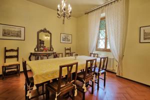 ein Esszimmer mit einem Tisch, Stühlen und einem Spiegel in der Unterkunft Villa Lo Scoiattolo by PosarelliVillas in Subbiano
