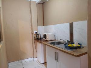a small kitchen with a sink and a microwave at The Glen House in Durban