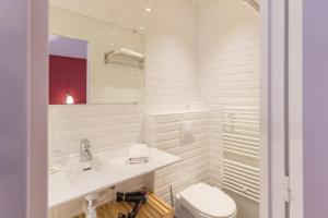 Un baño blanco con lavabo e inodoro. en Les Toits de Paris, en París 47 fotos más