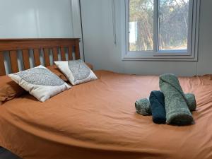 a bed with two stuffed animals laying on it at Timbuktoo Escape in Glen Creek