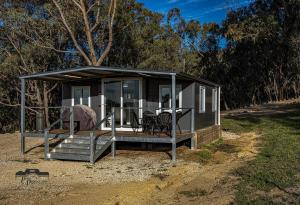 a tiny house with a porch and a deck at Timbuktoo Escape in Glen Creek