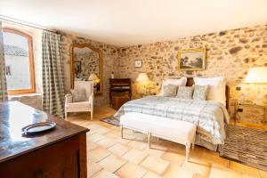 a bedroom with a bed in a room with stone walls at La Tour d'Enguerne in Montmeyan +57 photos