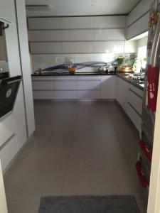 a large kitchen with white cabinets and a tile floor at Guest house Ashdod-beach in Ashdod