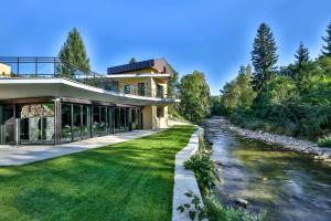 una casa con un río delante de ella en Hôtel Baud - Teritoria, en Bonne-sur-Ménoge