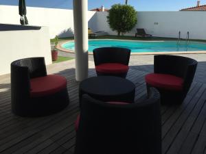 un patio avec quatre chaises et une piscine dans l'établissement Villa Família, à Ponta Delgada 10 autres photos