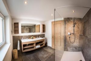 a bathroom with a shower and a sink at Hotel Hirlanda in Zürs am Arlberg +65 photos