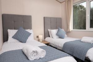 a bedroom with two beds with towels on them at Willow lodge in Brynteg