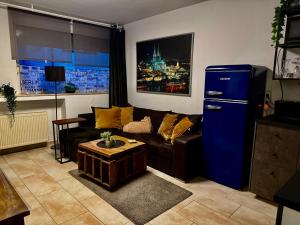 a living room with a couch and a blue refrigerator at Köln Apartment I in Cologne