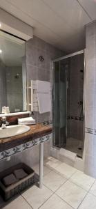 a bathroom with a sink and a shower at Hôtel Marguerite in Dinan +110 photos