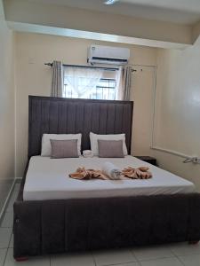 a bedroom with a large bed with white sheets and a window at Cozy 2 BR with 3 Beds, AC & Hot Shower at Buxton Point Apartments Off RG Road Gate A in Mombasa