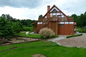 a house with a goat standing in front of it at Charbrowski Młyn in Wicko