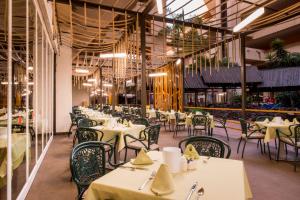 a restaurant with white tables and chairs and ceilings at Hotel Beatriz Playa & Spa in Puerto del Carmen