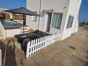 a patio with a table and an umbrella and a pool at Asteria Apartments in Hersonissos