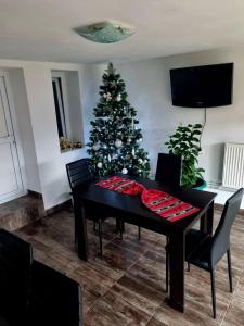 a black table with a christmas tree in a room at Casa Ostrov in Călimăneşti