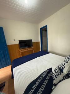 a bedroom with a bed and a flat screen tv at Pousada Dom Luiz in Ouro Preto