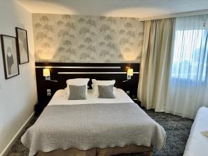 ein Schlafzimmer mit einem großen Bett und einem Fenster in der Unterkunft Hotel Chantereyne in Cherbourg en Cotentin