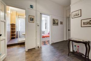 ローマにあるLa Casa dello Scrittoreの廊下、ベッド、テーブルが備わる客室です。