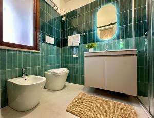 a green tiled bathroom with a toilet and a sink at Casa Manzella Apartments in Cinisi +32 photos