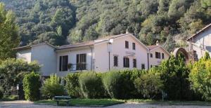une grande maison blanche en face d'une montagne dans l'établissement Il Casolare della Cascata, à Terni