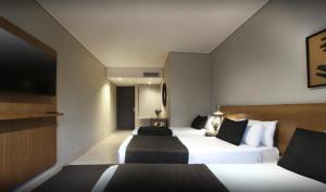 a hotel room with two beds and a flat screen tv at Agua del Corral Hotel & Spa in Mendoza