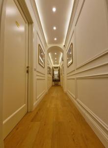 an empty hallway with white walls and wood floors at Gaglian's Suites Lake Como in Como