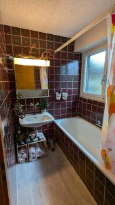 a bathroom with a tub and a sink and a mirror at Naturnah und familienfreundlich in Degersheim +23 photos
