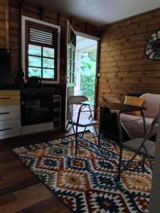 a living room with a table and chairs and a rug at Le Bon Refuge in Le Lamentin