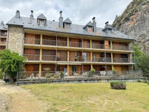 a large building with a mountain in the background at La Terraza de Escarrilla, con piscina in Escarrilla