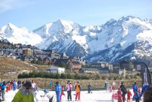 a group of people on skis in the snow with mountains at La Terraza de Escarrilla, con piscina in Escarrilla