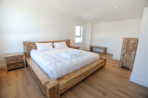 ein Schlafzimmer mit einem großen Bett mit Holzplattform in der Unterkunft Elios Private Spa & BBQ, Lake & Golf in Brownsburg