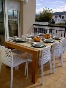 a table with plates and bowls of fruit on a balcony at Rainbow Home Coll Verd in Playa de Gandia +11 photos