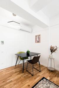 a dining room with a black table and chairs at Luxury Elegant Pipera New Apartment in Voluntari