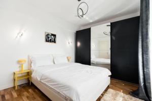 a bedroom with a white bed and a black wall at Luxury Elegant Pipera New Apartment in Voluntari