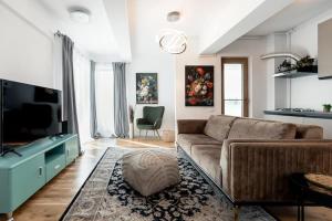 a living room with a couch and a flat screen tv at Luxury Elegant Pipera New Apartment in Voluntari