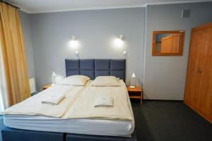 a bedroom with a large bed with two towels on it at Hotel Maraton in Kielce