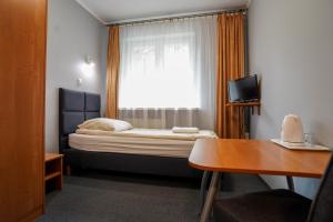 a small room with a bed and a window at Hotel Maraton in Kielce +32 photos