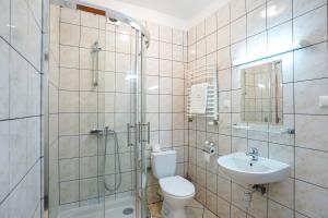 a bathroom with a shower and a toilet and a sink at Hotel Maraton in Kielce
