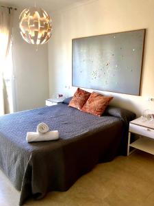 a bedroom with a bed with a large painting on the wall at Rainbow Home Coll Verd in Playa de Gandia